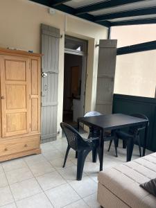 a black table and chairs in a room with a door at Appartement le Gallon in Langogne +6 photos