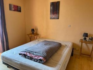 a bed sitting in a room with two lamps at Appartement le Gallon in Langogne