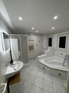 a large bathroom with a tub and a sink at Ferienwohnung Noela in Sankt Ingbert