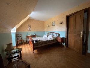 a bedroom with a bed and a wooden floor at La maison du pont du gué in Bourgueil