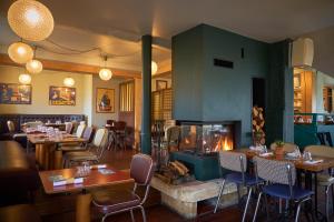 a restaurant with a fireplace and tables and chairs at Domaine Les Lanternes in Saint-Cyr-au-Mont-dʼOr