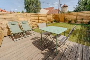a green table and two chairs on a deck at L'inavouable Love-room Jacuzzi in Marquise