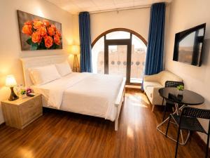 a bedroom with a bed and a table and a window at Royal International in Abu Dhabi