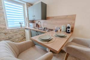 a kitchen with a wooden table and two chairs at L'inavouable Love-room Jacuzzi in Marquise +10 photos