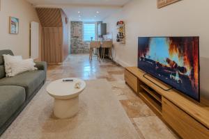 a living room with a large flat screen tv at L'inavouable Love-room Jacuzzi in Marquise