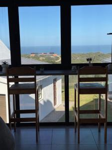 a table and two chairs in front of a window at Oceanview Stays in Great Brak River