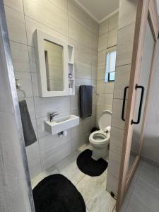 a bathroom with a toilet and a sink and a mirror at Oceanview Stays in Great Brak River +4 photos