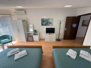a bedroom with a bed with a blue bedspread and a television at SIENA Apartment in Gevgelija