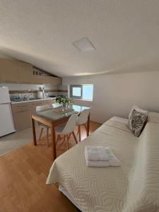 a bedroom with a bed and a table and a kitchen at SIENA Apartment in Gevgelija +14 photos