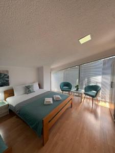 a bedroom with a bed and two chairs and a window at SIENA Apartment in Gevgelija