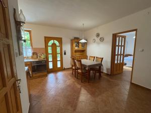a kitchen and dining room with a table and chairs at Éva Apartmanház 2 in Csopak