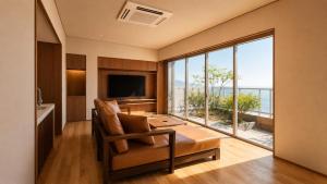 a living room with a couch and a large window at AMANE resort SEIKAI in Beppu