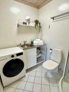 a bathroom with a sink and a washing machine at GG Village in Askim +18 photos