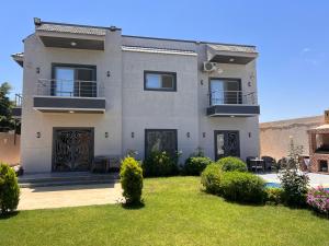 a house with a lawn in front of it at King mariout villa LA FIESTA in Borg El Arab