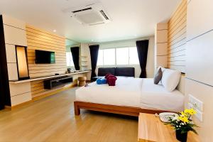 pokój hotelowy z łóżkiem i telewizorem w obiekcie Anda Beachside Hotel w mieście Karon Beach