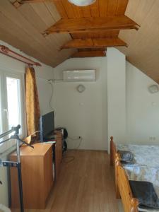a room with a bed and a desk with a television at Balaton Sunset apartman in Balatonfůzfő