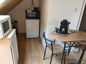 a small kitchen with a table and a microwave at Balaton Sunset apartman in Balatonfůzfő