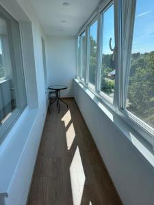 a room with a table and two windows at Bright & Brand New Appartment in Liepāja