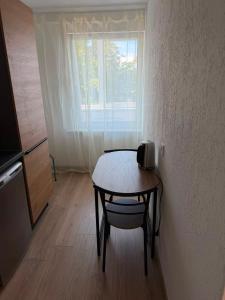 a small table in a room with a window at Bright & Brand New Appartment in Liepāja +2 photos
