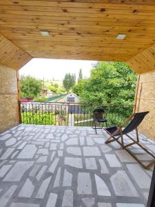 a patio with two chairs and a wooden ceiling at biker s home in Nabakhtevi
