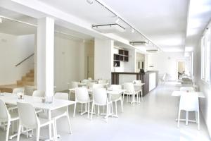 a dining room with white tables and white chairs at Hotel with breakfast included in Palau in Proiettore +11 photos