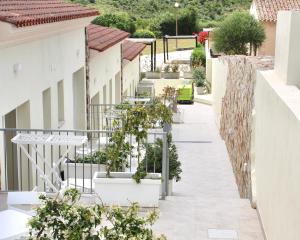 a walkway with potted plants on a building at Hotel with breakfast included in Palau in Proiettore