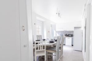 a white kitchen with a dining room table and chairs at Hello Flat - Maison de ville près de Paris in Athis-Mons