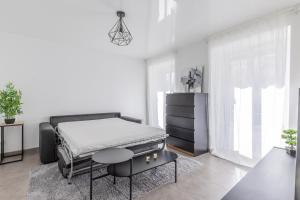 a white bedroom with a bed and a table at Hello Flat - Maison de ville près de Paris in Athis-Mons