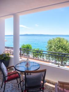 a balcony with a table and chairs and the ocean at APARTMANI Mirona - Tučepi in Tučepi
