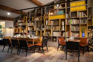 a dining room with a table and chairs and bookshelves at Domaine Les Lanternes in Saint-Cyr-au-Mont-dʼOr