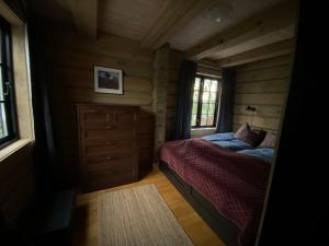 a bedroom with a bed in a log cabin at Koslig helårs hytte in Heimdal +12 photos