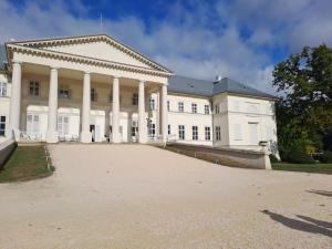 a large white building with a large driveway at Garden House in Dég