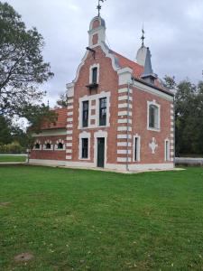 a large brick building with a tower on top of a field at Garden House in Dég