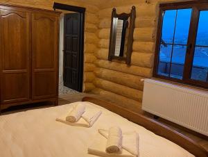 a bedroom with a bed with two towels on it at Chalet Poligon in Vatra Dornei