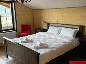 a bedroom with a large bed with two towels on it at Chalet Poligon in Vatra Dornei
