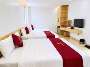 two beds in a hotel room with a television at Nhật Lệ River Hotel Quảng Bình in Huân Cát +29 photos
