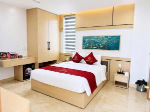 a bedroom with a large bed with red pillows at Nhật Lệ River Hotel Quảng Bình in Huân Cát