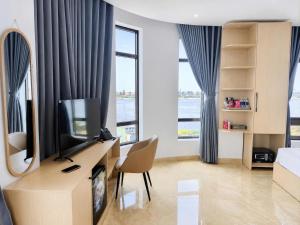 a bedroom with a desk with a tv and a mirror at Nhật Lệ River Hotel Quảng Bình in Huân Cát
