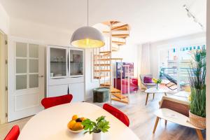 a living room with a white table and red chairs at Breathtaking Penthouse Las Azaleas in Torrox