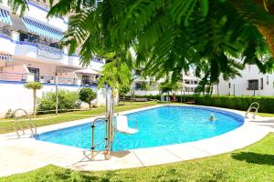 a swimming pool in front of a building at Breathtaking Penthouse Las Azaleas in Torrox