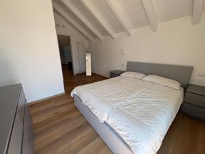 a bedroom with a white bed and a television at Mansarda Alla Palma in Intra