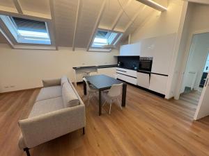 a living room with a couch and a table at Mansarda Alla Palma in Intra