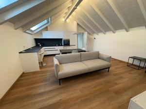a living room with a couch and a kitchen at Mansarda Alla Palma in Intra