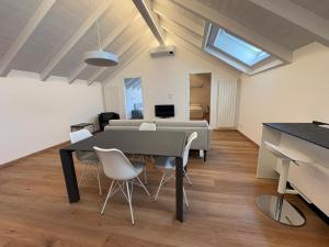 a dining room and living room with a table and chairs at Mansarda Alla Palma in Intra +3 photos