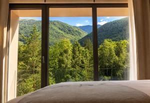 ein Schlafzimmer mit Blick auf die Berge durch ein Fenster in der Unterkunft Pine Hotel & Spa Brezovice in Brezovica