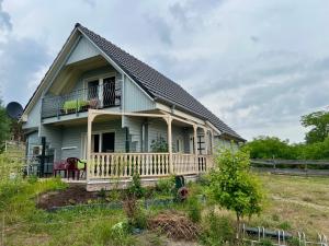 a house with a porch and a balcony at Holzhaus am Waldrand in Niederfinow
