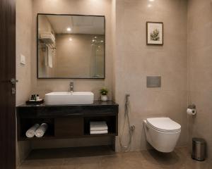 a bathroom with a sink and a toilet and a mirror at Hotel La Serene in Agra