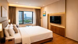 a hotel room with a bed and a television at Pride Plaza Indore in Indore