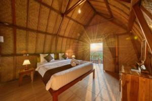 a bedroom with a large bed in a wooden room at The Penida Angmas View in Nusa Penida