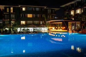 a large swimming pool in front of a building at night at Wing 4203 - Modern Resort Studio Koh Samui in Bophut